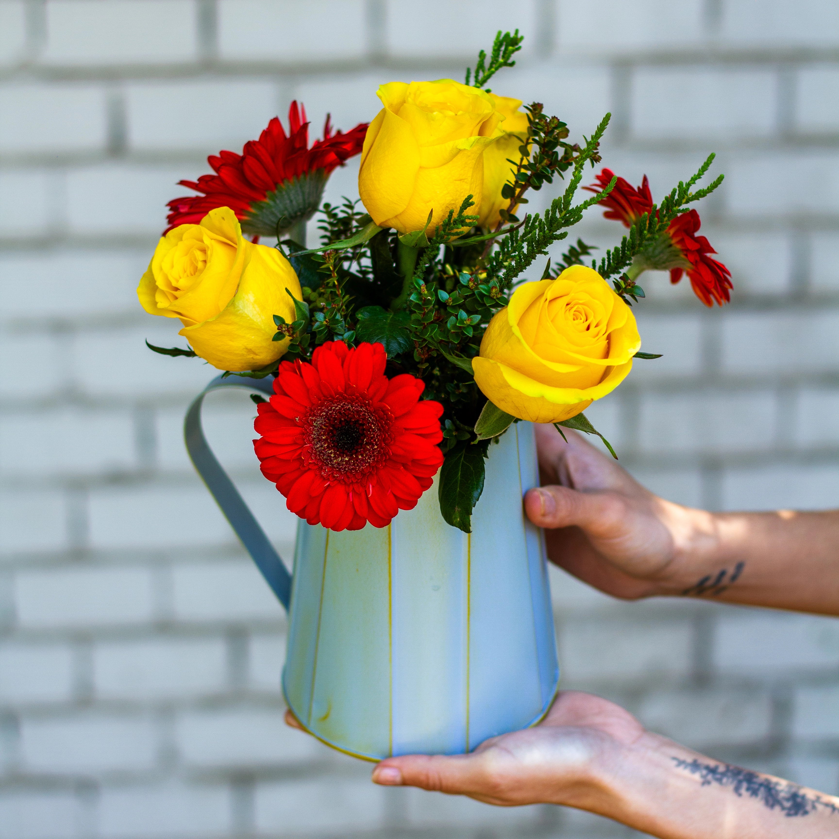 Jarrita celeste de metal con gerberas y rosas